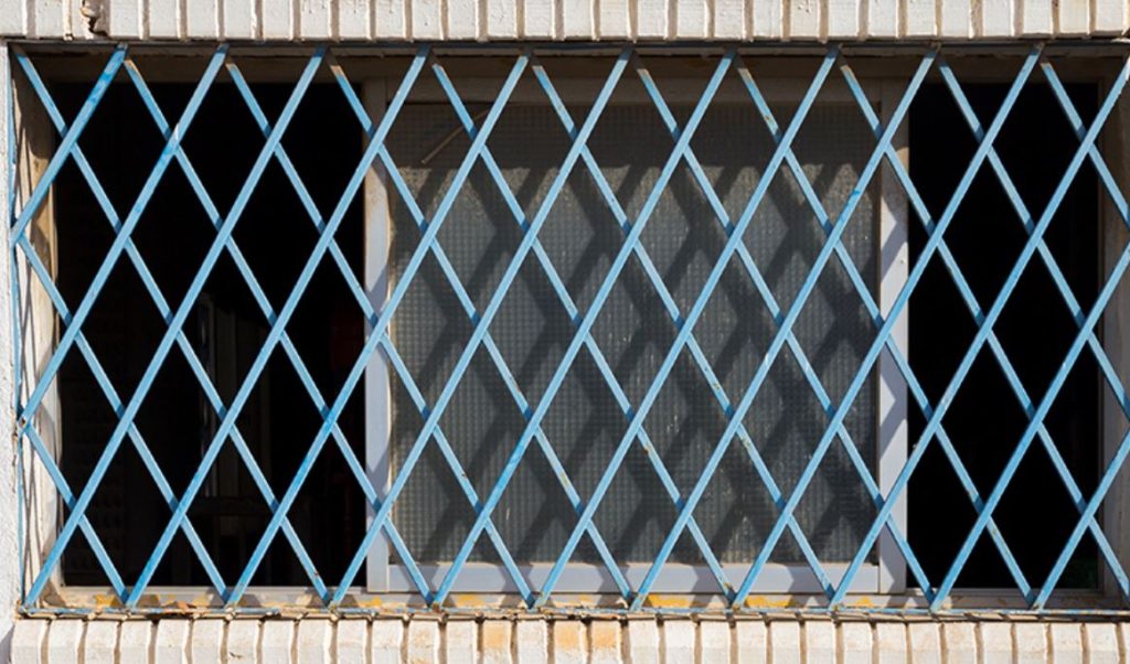 A window with a blue window grill on it. 